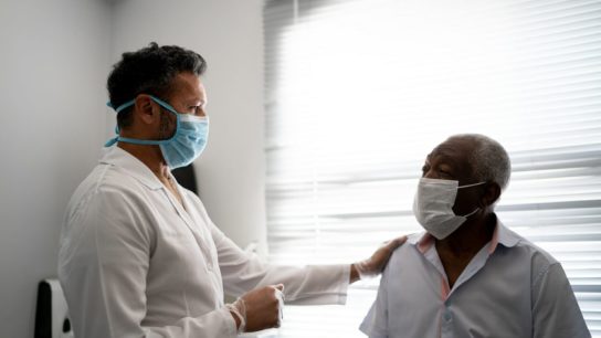 doctor with older Black patient wearing mask