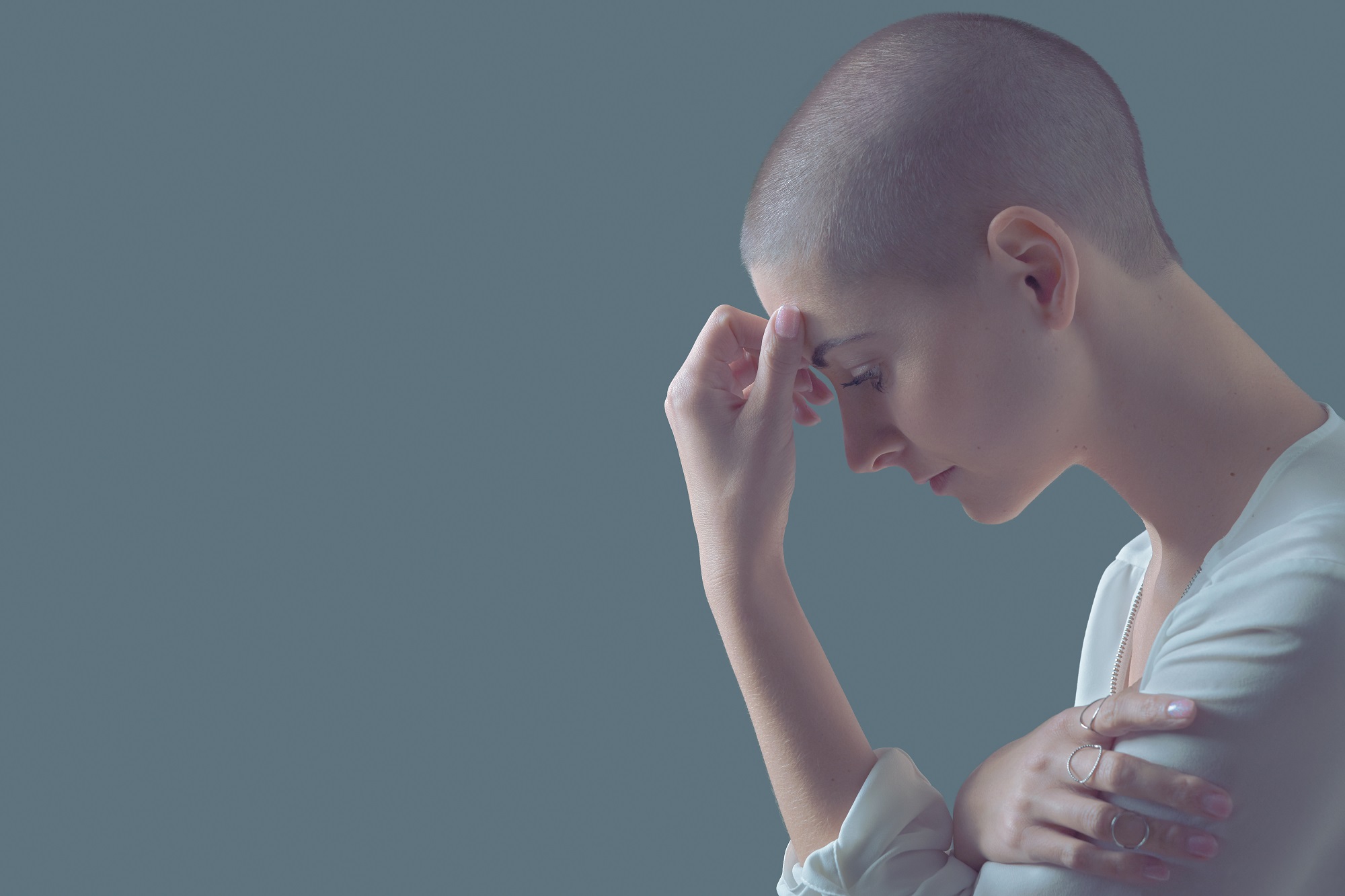 woman with cancer touching her forehead