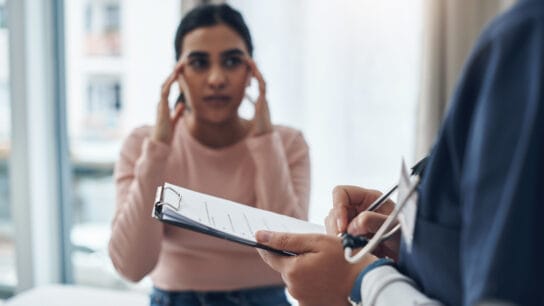 Shot of an unrecognizable doctor writing down a patient's information in an office