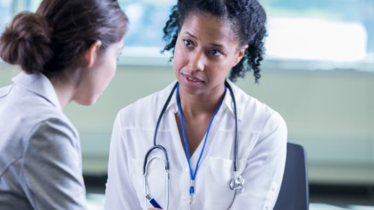 Doctor compassionately listens to female patient