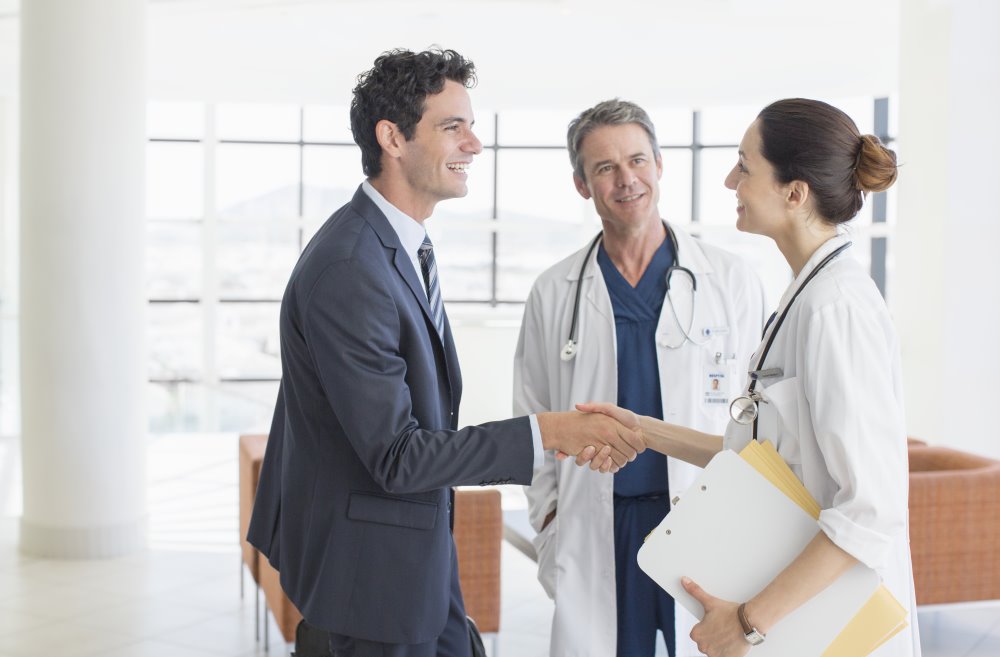 Doctors shake hands with businessman
