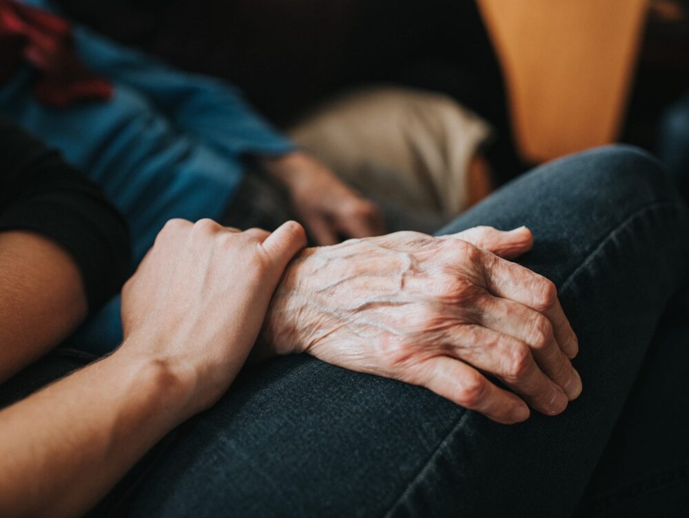 Conceptual. Younger person holding an older persons hand.