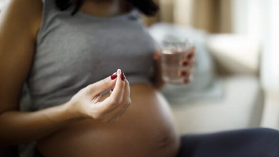 Pregnant-woman-taking-pill-at-home