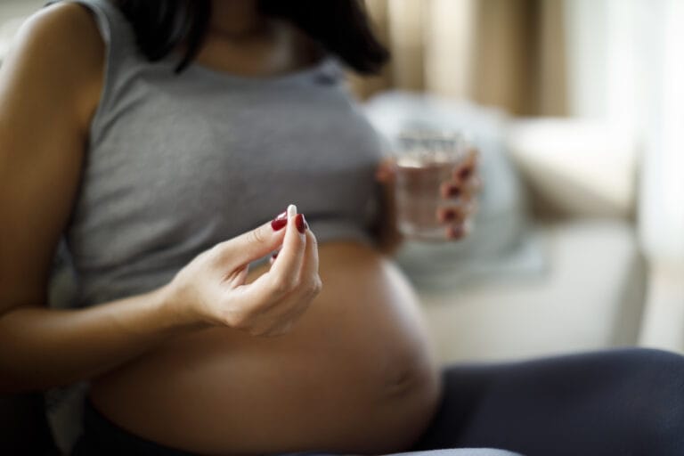 Pregnant-woman-taking-pill-at-home