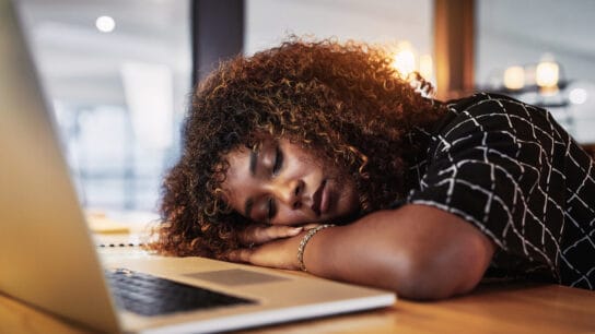 young woman sleeping at desk