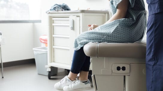 Female-nurse-examining-adolescent-patient-in-clinic.
