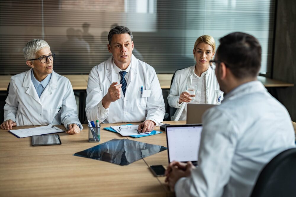 Team-of-doctors-communicating-with-their-colleague-during-a-meeting-in-the-office.