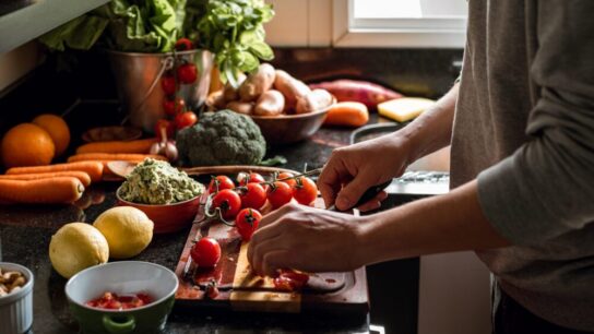Shot-of-a-vegan-meal-preparation-with-lots-of-vegetables-and-fruits-on-a-domestic-kitchen