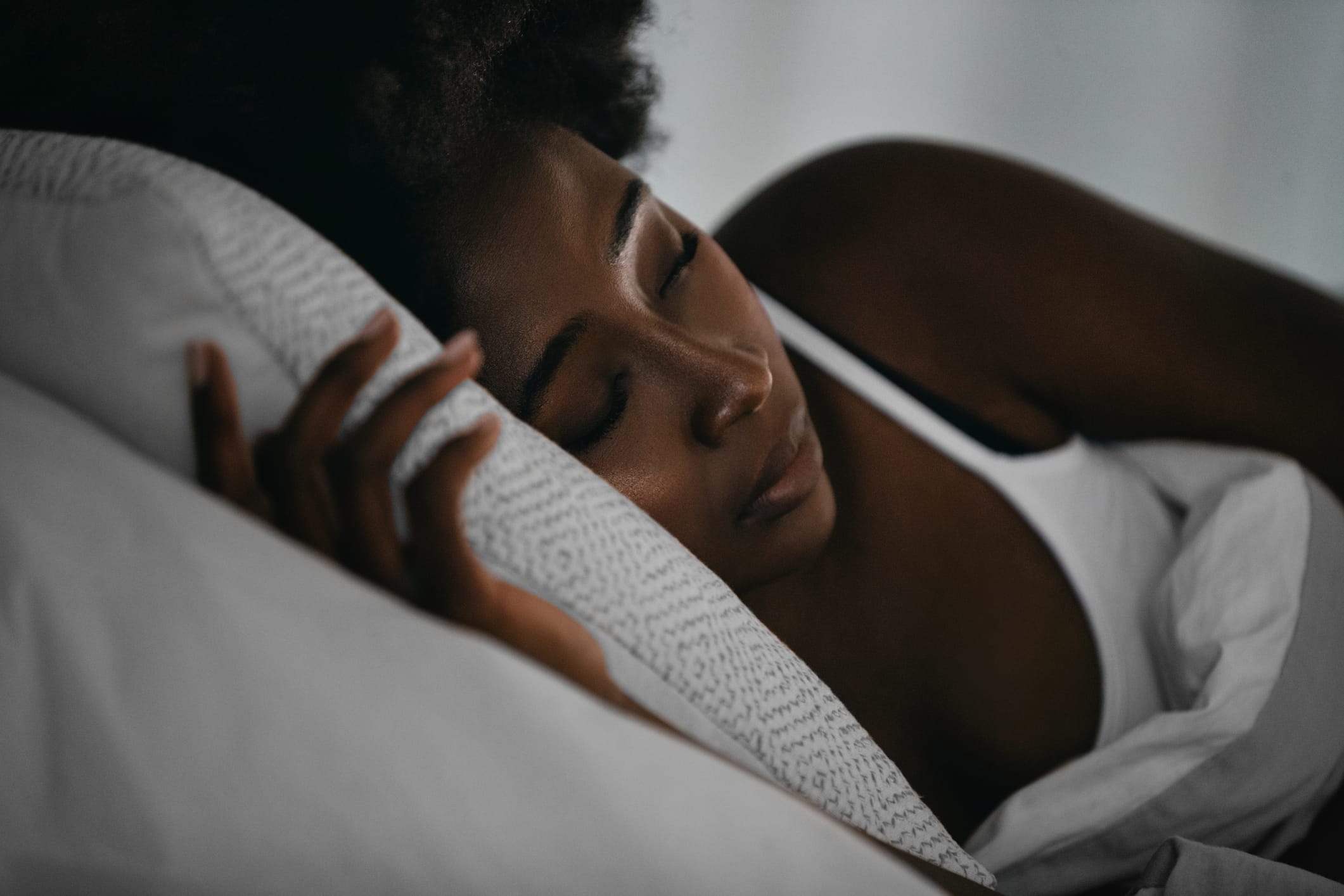 Young Black woman sleeping in bed