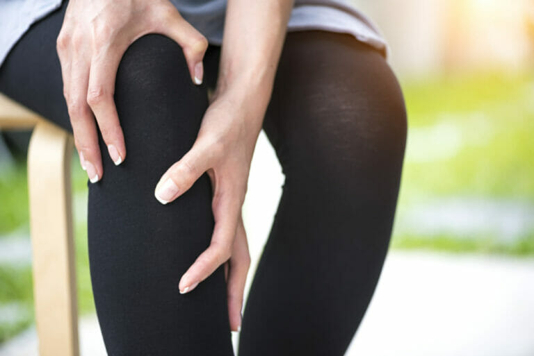 an-individual-pressing-hands-against-pain-in-knee