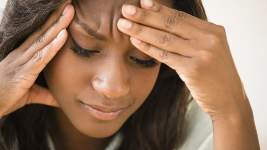 woman with hands holding head