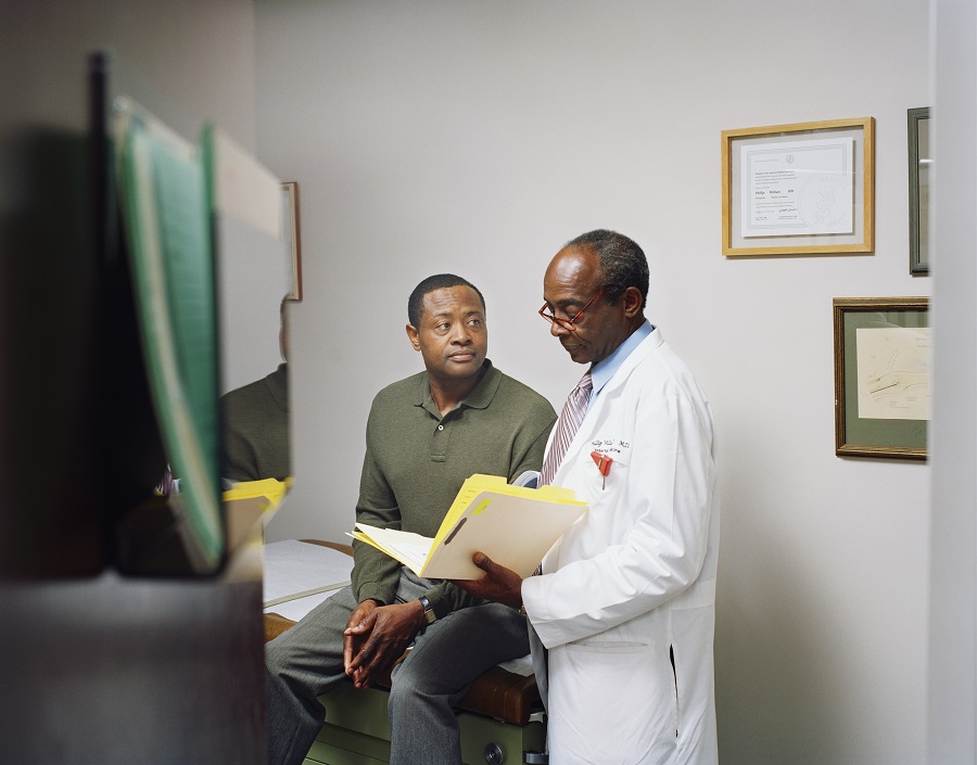 male doctor standing next to male patient