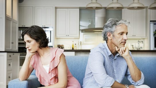 man and woman sitting back to back