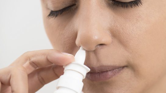 woman using nasal spray